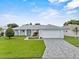Charming single-story home with a patterned driveway and lush landscaping at 5771 Macaw Pl, Lakeland, FL 33809