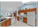 Functional kitchen with wood cabinets, white appliances, and a high ceiling at 5771 Macaw Pl, Lakeland, FL 33809