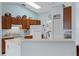 Traditional kitchen with wooden cabinets, white appliances, and an eat-in counter at 5771 Macaw Pl, Lakeland, FL 33809