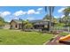 Spacious backyard featuring a screened pool area, playset, and lush landscaping for outdoor enjoyment at 5819 Hollyhock Dr, Lakeland, FL 33813