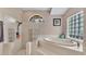 Bright bathroom featuring a soaking tub, glass block window, and updated shower at 5819 Hollyhock Dr, Lakeland, FL 33813