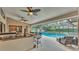 Backyard patio with full kitchen, ceiling fans, dining area, lounge seating and a pool with protection at 5819 Hollyhock Dr, Lakeland, FL 33813