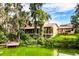 Scenic backyard view featuring a lake, dock, mature trees, and the home's exterior at 6033 Mountain Lake Dr, Lakeland, FL 33813