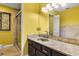 Bathroom with a shower, granite countertop, and yellow wall paint at 6033 Mountain Lake Dr, Lakeland, FL 33813