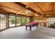 Bright game room with wood walls, a pool table, and large windows overlooking the outdoors at 6033 Mountain Lake Dr, Lakeland, FL 33813