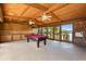 Large game room with wooden walls, a red pool table, built-in bar, and natural light at 6033 Mountain Lake Dr, Lakeland, FL 33813