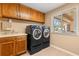 Laundry room features front loading washer and dryer, window and shelving, plus storage cabinets and a folding counter at 6033 Mountain Lake Dr, Lakeland, FL 33813