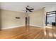 Bright living room boasts hardwood floors, ceiling fan, access to a bathroom, and an entry to the staircase at 6033 Mountain Lake Dr, Lakeland, FL 33813