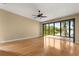 Spacious living room featuring hardwood floors, ceiling fan, and sliding glass doors to a screened porch with lake views at 6033 Mountain Lake Dr, Lakeland, FL 33813