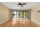 Open living room with wood flooring and lake views through large windows and sliding doors to the screened porch at 6033 Mountain Lake Dr, Lakeland, FL 33813