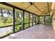 Enclosed patio with beautiful tiled floor and view of backyard lake and nature at 6033 Mountain Lake Dr, Lakeland, FL 33813