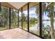 Bright sunroom with tile flooring, large windows overlooking the lake and lush greenery at 6033 Mountain Lake Dr, Lakeland, FL 33813
