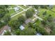 Aerial view of the home nestled among mature trees, with a detached carport and large grassy yard at 615 N Church Ave, Fort Meade, FL 33841