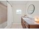 Stylish bathroom features a shower-tub combo, a sink with vanity, and a round mirror at 615 N Church Ave, Fort Meade, FL 33841