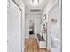 Well-lit hallway with wood floors, a bench, and access to the bathroom and other rooms at 615 N Church Ave, Fort Meade, FL 33841