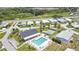 Panoramic aerial view of a charming community showcasing a pool, shuffleboard court, and community center at 6443 Hollyberry Ne Ln, Winter Haven, FL 33881