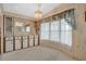 Traditional dining room with large window, chandelier, and storage cabinets at 6443 Hollyberry Ne Ln, Winter Haven, FL 33881