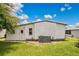 Home exterior showcasing white siding, lush lawn, and utility access with an air conditioning unit at 6443 Hollyberry Ne Ln, Winter Haven, FL 33881