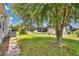 Cozy home exterior with green lawn, mature trees, and ample outdoor space to enjoy at 6443 Hollyberry Ne Ln, Winter Haven, FL 33881