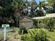 Attached garage with a neutral door, set amongst mature greenery and a colorful mailbox at 645 Avenue A Ne, Winter Haven, FL 33881