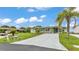 Charming single-story home with a well-manicured lawn, a long driveway, and mature palm trees at 6509 Oak Hammock Ct, Winter Haven, FL 33884