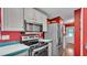 Kitchen showcasing stainless steel appliances, tiled countertops and a red wall at 6509 Oak Hammock Ct, Winter Haven, FL 33884