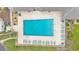 Aerial view of a rectangular pool with sun loungers and chairs, surrounded by a paved area and landscaping at 6509 Oak Hammock Ct, Winter Haven, FL 33884