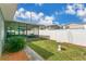 A fully fenced backyard featuring lawn, landscaping, a screened pool enclosure, and clear blue skies at 686 22Nd Nw St, Winter Haven, FL 33880