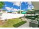 Cozy backyard featuring a lush lawn, patio with seating, and a screened-in porch with spa at 686 22Nd Nw St, Winter Haven, FL 33880