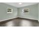A bright bedroom featuring hard surface floors, light blue walls, and two windows bringing in natural light at 686 22Nd Nw St, Winter Haven, FL 33880