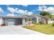 Charming home with a well-manicured front yard, gray siding, a garage, and a freshly paved driveway at 686 22Nd Nw St, Winter Haven, FL 33880