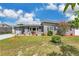 Charming gray single-story home featuring a manicured front yard with a beautiful blossoming tree at 686 22Nd Nw St, Winter Haven, FL 33880