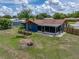 Aerial view of a well-maintained backyard with a screen room, lush lawn, and a beautiful palm tree at 7150 Orange Way, Lakeland, FL 33810