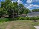 Expansive backyard view with mature trees, partial fencing, and ample space for outdoor activities at 7150 Orange Way, Lakeland, FL 33810