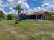 Spacious backyard view featuring a screen room, palm tree, and ample lawn at 7150 Orange Way, Lakeland, FL 33810