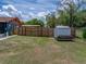 Large fenced backyard with a storage shed and ample open space for outdoor enjoyment at 7150 Orange Way, Lakeland, FL 33810