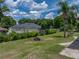 Lush backyard with a palm tree, well-kept lawn, partial fencing, and neighbor's home at 7150 Orange Way, Lakeland, FL 33810