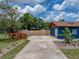 Side yard featuring a large concrete pad, plants, and privacy fence at 7150 Orange Way, Lakeland, FL 33810