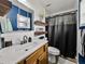 Updated bathroom with new vanity, toilet, shelves, mirror, and a shower with gray curtain at 7150 Orange Way, Lakeland, FL 33810