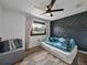 Charming bedroom with a unique accent wall, modern ceiling fan, and plank flooring at 7150 Orange Way, Lakeland, FL 33810