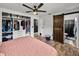 Bedroom featuring closet system, modern ceiling fan, and dark wood sliding barn door to bathroom at 7150 Orange Way, Lakeland, FL 33810