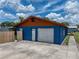 View of the detached garage showing the door, side door, and driveway at 7150 Orange Way, Lakeland, FL 33810