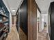 Hallway featuring wood plank flooring, shelving, and a black accent wall at 7150 Orange Way, Lakeland, FL 33810