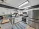 Bright kitchen boasts stainless steel appliances and a stylish blue patterned rug at 7150 Orange Way, Lakeland, FL 33810