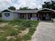 Exterior shot of property showing the house, overgrown yard, and driveway at 745 Drawdy Rd, Babson Park, FL 33827