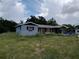 Exterior shot of property showing the house and overgrown yard at 745 Drawdy Rd, Babson Park, FL 33827