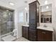This bathroom offers dual vanities, a glass shower, and a linen closet for ample storage at 8219 Rangers Path, Lakeland, FL 33809
