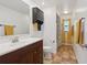 Well-lit bathroom features a single vanity, tile floors, and shower with tub at 8219 Rangers Path, Lakeland, FL 33809