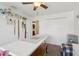 Well-lit bedroom with ceiling fan, storage shelves, closet, and craft table at 8219 Rangers Path, Lakeland, FL 33809
