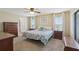 This primary bedroom is bright and airy with a ceiling fan and neutral decor at 8219 Rangers Path, Lakeland, FL 33809
